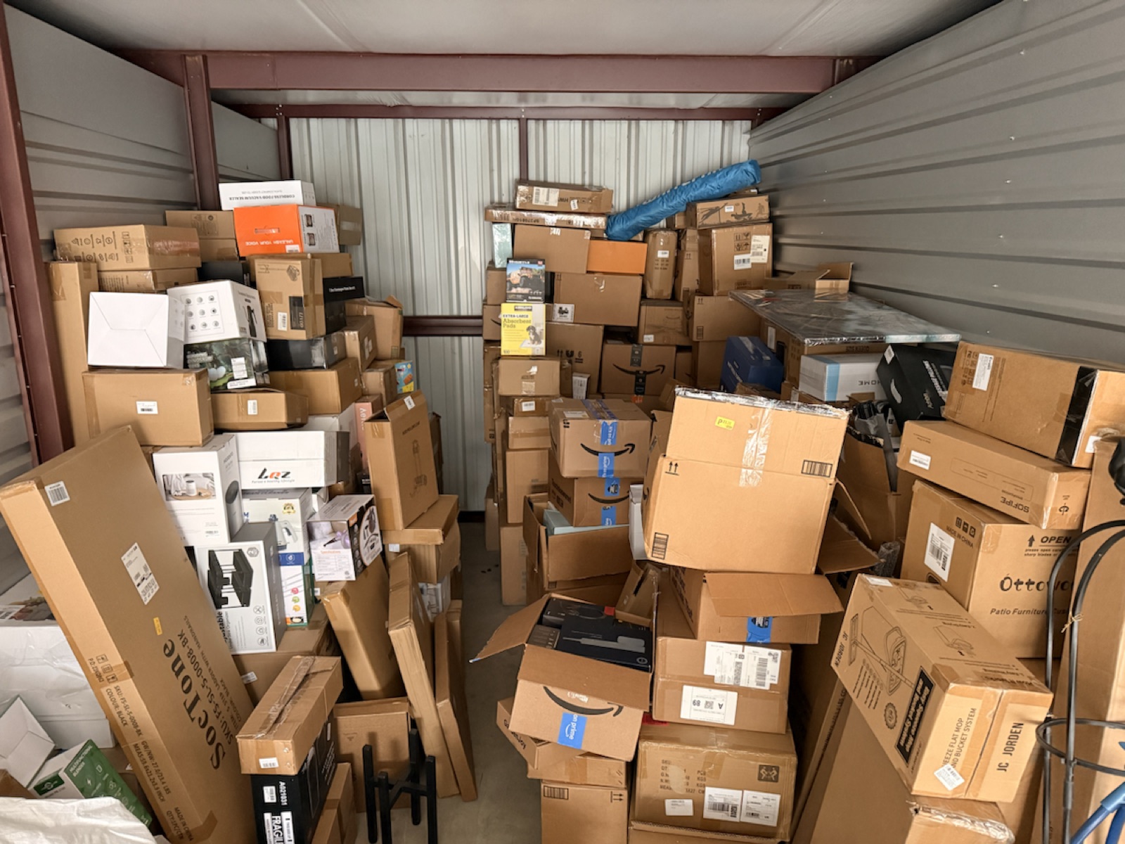 Wide photo of storage unit filled with Amazon overstock boxes and mixed inventory in New Jersey